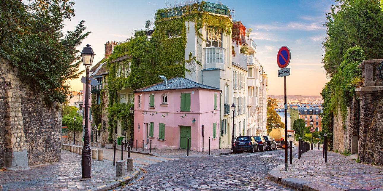 Gemütliche alte Straße mit rosa Haus am sonnigen Sonnenaufgang, Viertel Montmartre in Paris, Frankreich