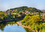 Der Blick auf Podgorica offenbart die idyllische Lage der Stadt am Fluss Morača, umgeben von bewachsenen Hügeln und kleinen Ortschaften.