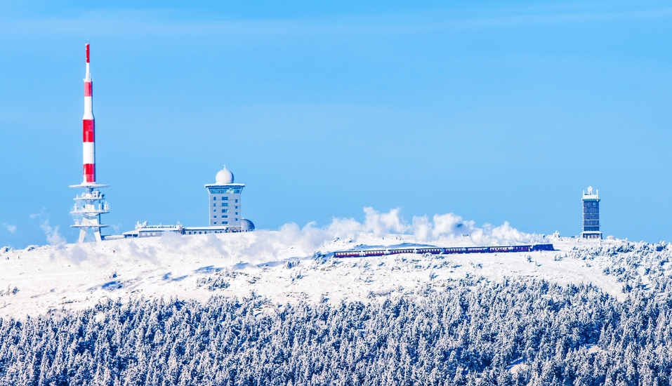 Die Brockenbahn schlängelt sich im Winter durch die verschneite Landschaft bis hinauf zum Brocken.