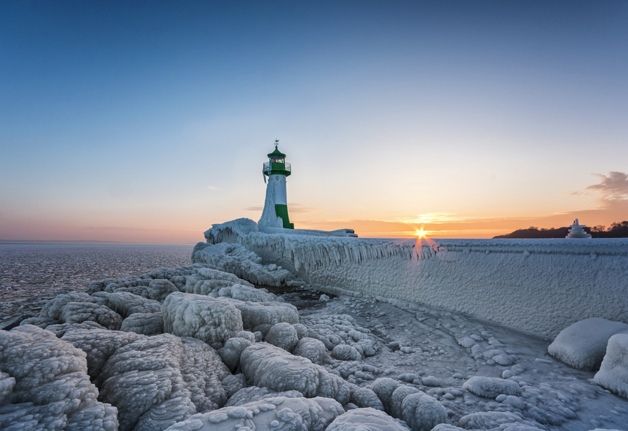 Leuchtturm in Sassnitz auf der Insel Rügen im Winter, umgeben von Eis und Schnee.
