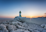 Leuchtturm in Sassnitz auf der Insel Rügen im Winter, umgeben von Eis und Schnee.