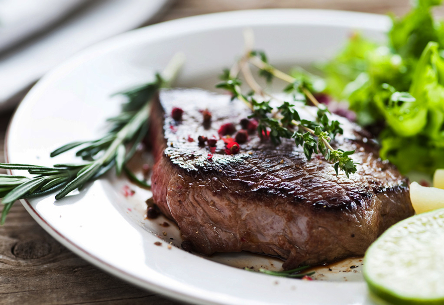 Lassen Sie sich im Restaurant ein saftiges Steak vom Grill schmecken.