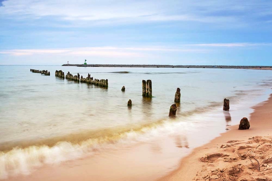 Genießen Sie die salzige Meeresluft am langen Sandstrand.