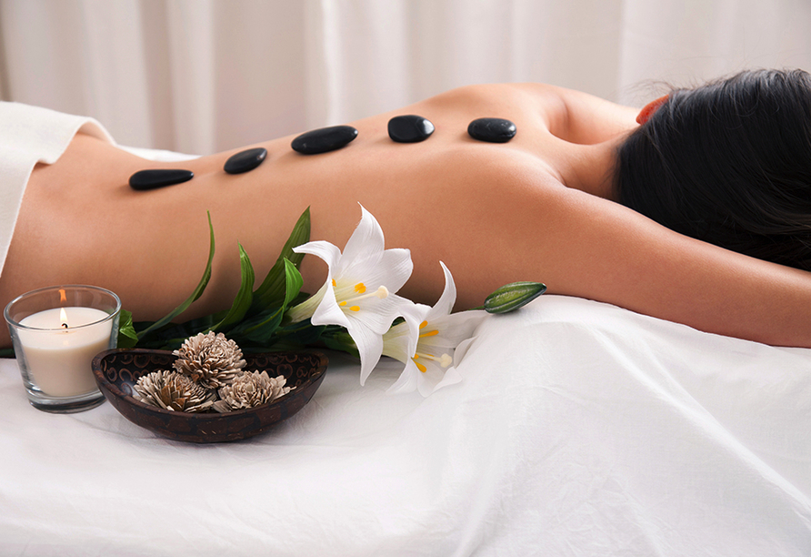 Entspannen Sie bei einer Hot-Stone-Massage im Wellnessbereich.