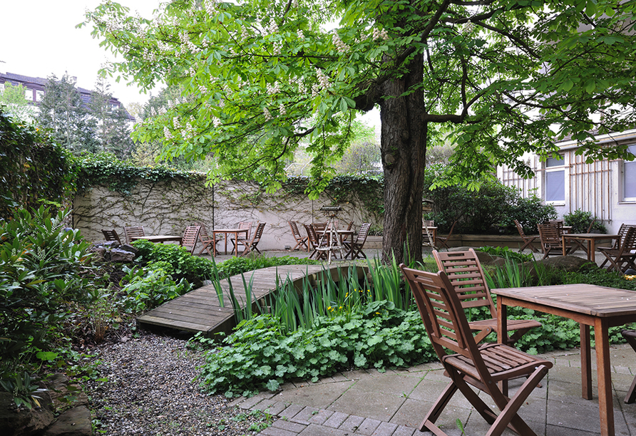 Genießen Sie Ihre Auszeit auf der ruhigen Terrasse mit Blick ins Grüne.