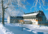 Das Panorama Berghotel Wettiner Höhe ist im Winter in einen weißen Mantel eingehüllt.