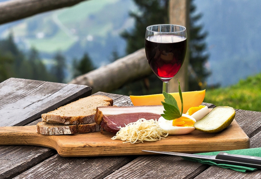 Genießen Sie auf einer Alm eine herzhafte Brotzeit.