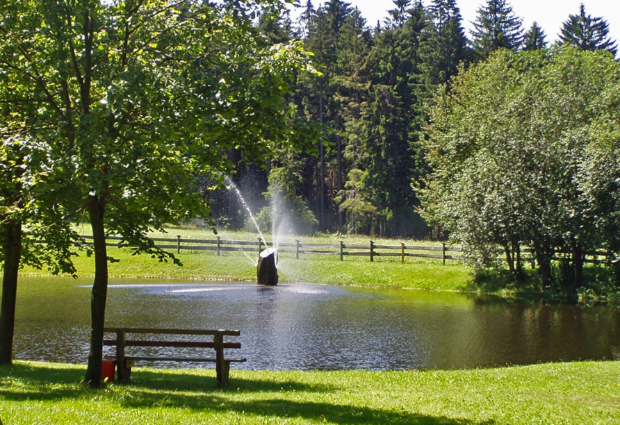 Der idyllische See am Sporthotel Sonnenhof lädt zum Verweilen ein.