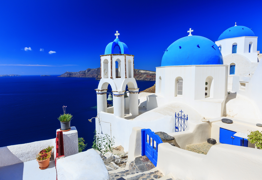  Weißgetünchte Häuser und Kirchen mit ikonischen blauen Kuppeln machen Santorini zu einem weltbekannten Postkartenmotiv. 