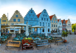 Am Marktplatz von Friedrichstadt sehen Sie die vielen bunten und historischen Treppengiebel der Häuserfassade.