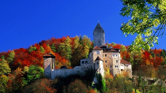 Die romantische Burg Kipfenberg ist im Herbst umgeben von farbenfrohen Bäumen.