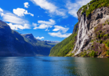 Der UNESCO-geschützte Geirangerfjord ist umgeben von majestätischen, schneebedeckten Berggipfeln, wilden Wasserfällen und grünen Tälern.
