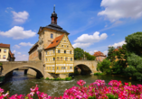 Zahlreiche historische Sehenswürdigkeiten, wie das Rathaus über dem Fluss Regnitz, erwarten Sie in Bamberg.