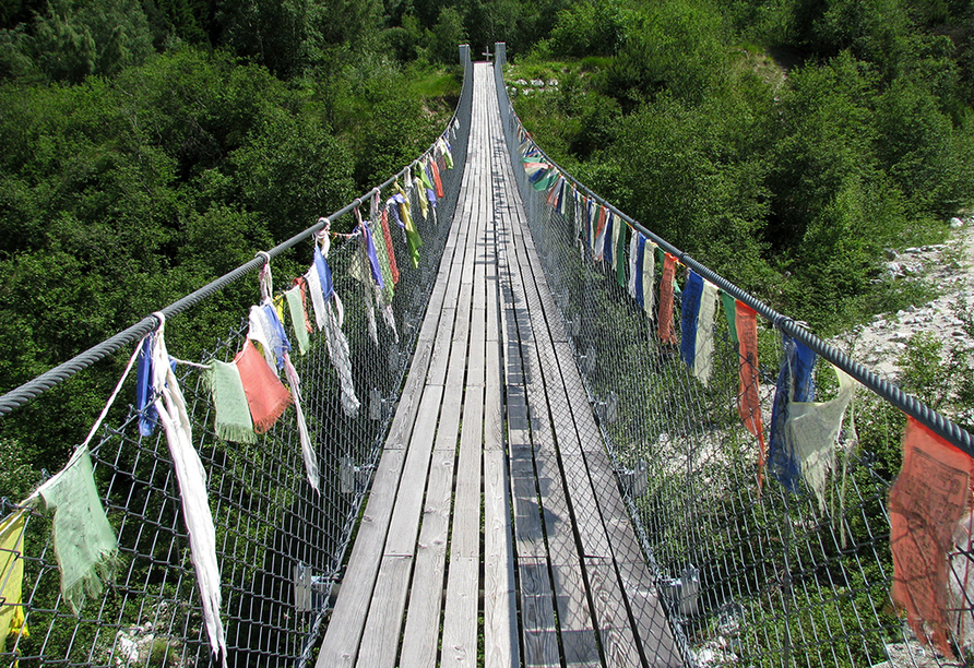 Die Brücke, die den deutschsprachigen mit dem französischen Teil des Wallis verbindet, ist mit bunten Gebetsfahnen geschmückt.