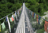 Die Brücke, die den deutschsprachigen mit dem französischen Teil des Wallis verbindet, ist mit bunten Gebetsfahnen geschmückt.