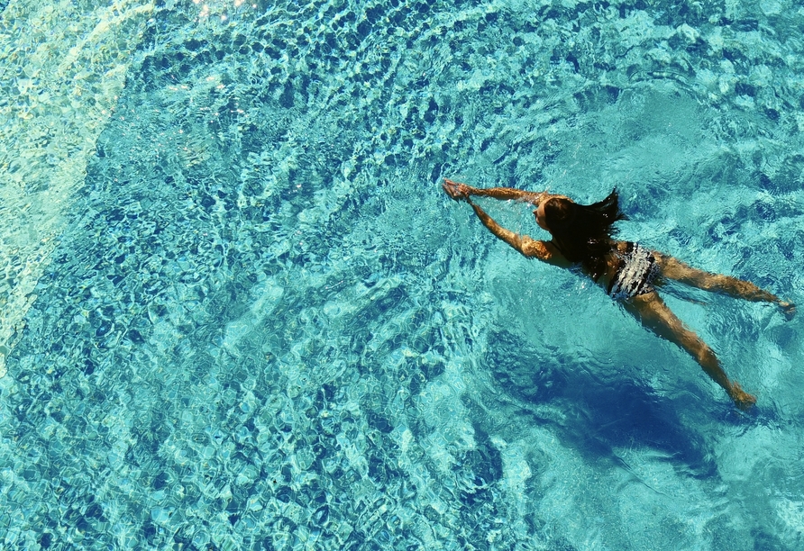 Frau schwimmt im Pool.