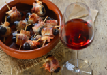 Probieren Sie leckere Tapas: Getrocknete Pflaumen in Speck gerollt und gebraten, dazu ein Glas Old Tawny Portwein.