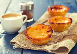 Zur perfekten Reise gehört auch die heimische Küche: Probieren Sie die köstlichen Pastéis de Nata.