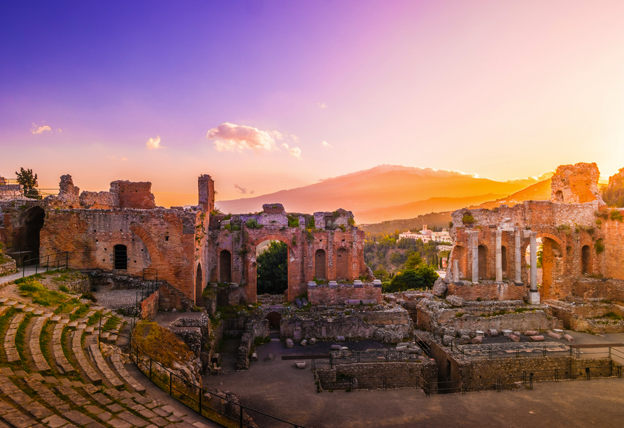 Lassen Sie sich vom Anblick des griechisch-römischen Theaters in Taormina mit dem Ätna im Hintergrund beeindrucken.