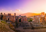 Lassen Sie sich vom Anblick des griechisch-römischen Theaters in Taormina mit dem Ätna im Hintergrund beeindrucken.
