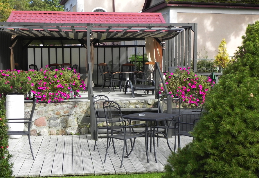 Nehmen Sie auf der Terrasse im kleinen Garten Platz.