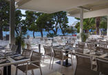 Genießen Sie regionale und internationale Speisen auf der hoteleigenen Terrasse mit Meerblick.