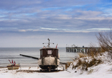 Fischerboote am Strand der Ostseeküste im Winter.