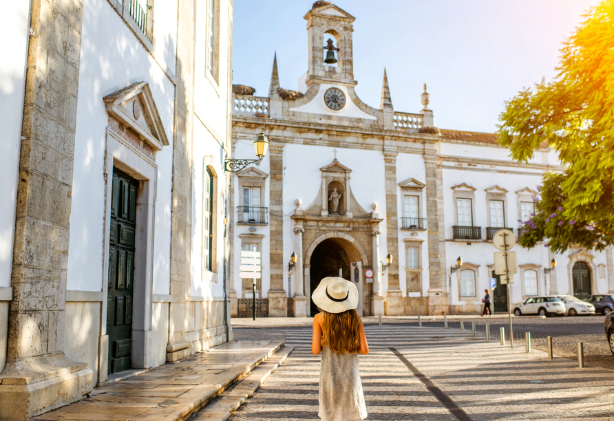 Schlendern Sie durch die charmanten Gassen von Faro und lassen Sie sich von der beeindruckenden Architektur und dem warmen Licht verzaubern.