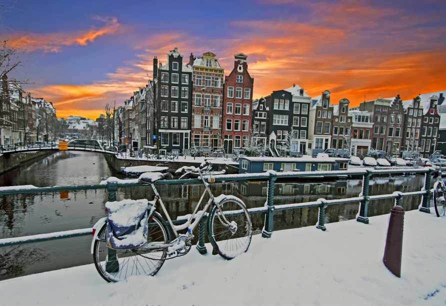 Erkunden Sie Amsterdam – mit etwas Glück wird die Metropole an Ihrem Reisetermin von einer romantischen Schneeschicht bedeckt.