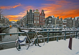 Erkunden Sie Amsterdam – mit etwas Glück wird die Metropole an Ihrem Reisetermin von einer romantischen Schneeschicht bedeckt.