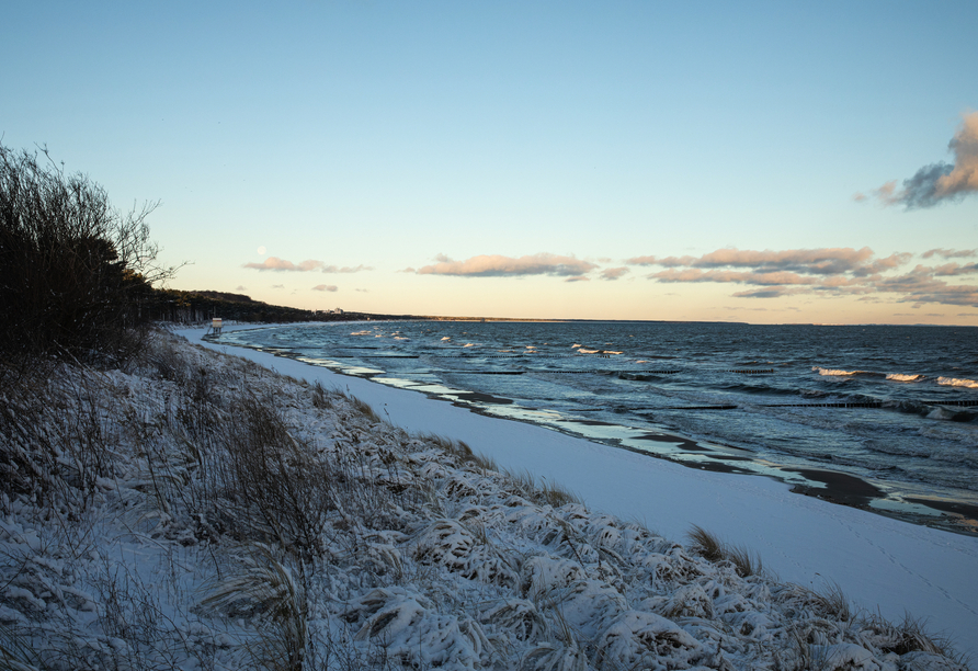 Unternehmen Sie einen winterlichen Spaziergang am Strand.