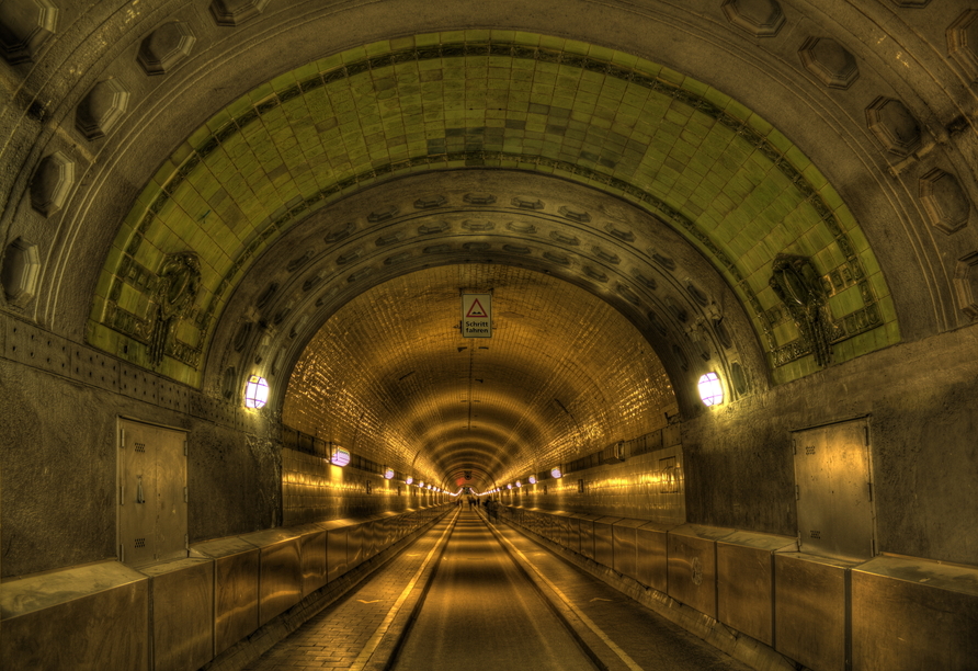 Spazieren Sie durch den alten Elbtunnel und gelangen Sie auf die andere Seite der Elbe.