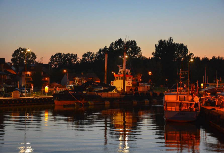 Der kleine Fischerhafen von Łeba scheint romantisch in der Abenddämmerung.