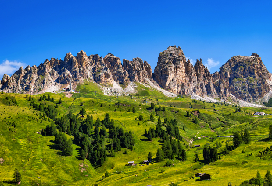 Die Dolomiten inklusive Berghütten und grünen Wiesen in Südtirol.