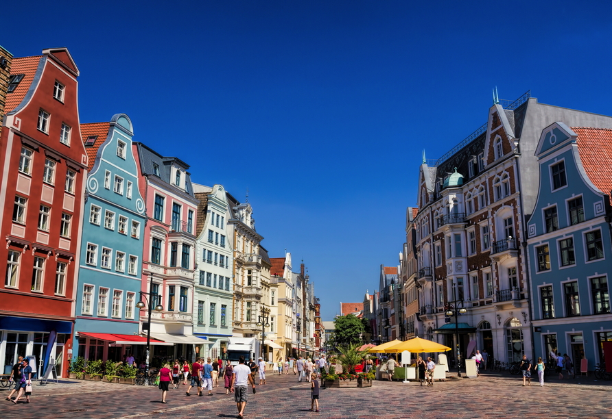 Schlendern Sie durch die Kröpeliner Straße mit farbenfrohen Altbauten in Rostock.