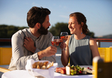 Genießen Sie vorbeiziehende Landschaften bei einem Essen an Deck.