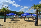 Im Beachclub entspannen Sie unter Palmen und schauen den Wakeboardern auf dem Wasser zu.
