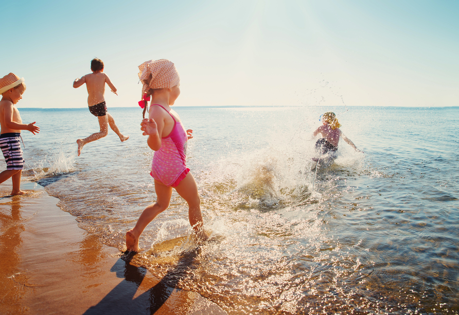 Kinder haben viel Spaß beim Planschen in der Ostsee.