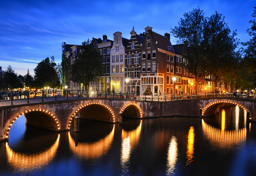 Machen Sie eine Fahrt durch die beleuchteten Grachten in Amsterdam.