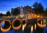 Machen Sie eine Fahrt durch die beleuchteten Grachten in Amsterdam.
