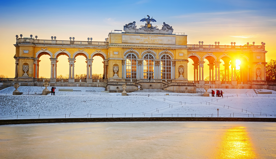 Die Sonne strahlt im Winter durch die Gloriette, welche am Schloss Schönbrunn steht.