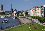 Flanieren Sie entlang der schönen Rheinuferpromenade in Düsseldorf.