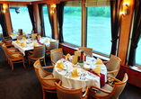 Beobachten Sie im Panorama-Restaurant an Bord die vorbeiziehende Landschaft.