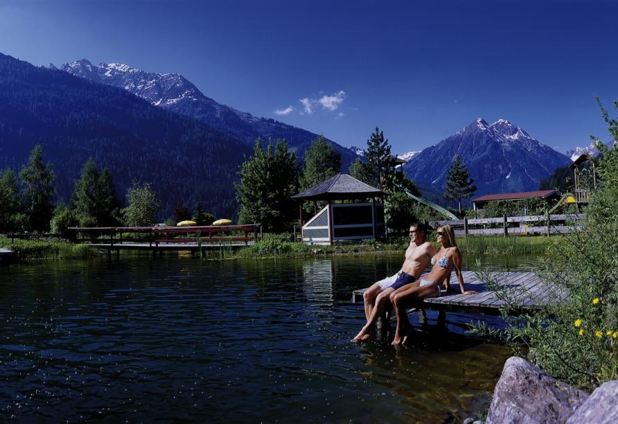 Genießen Sie eine Auszeit am schönen Naturschwimmteich des Hotels.