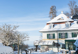 Das Hotel Schlossgut Oberambach im Winter - von einer glitzernden Schneedecke überzogen.