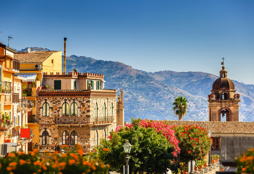 Taorminas historische Gassen vor der eindrucksvollen Bergkulisse laden dazu ein, Siziliens Charme hautnah zu erleben.