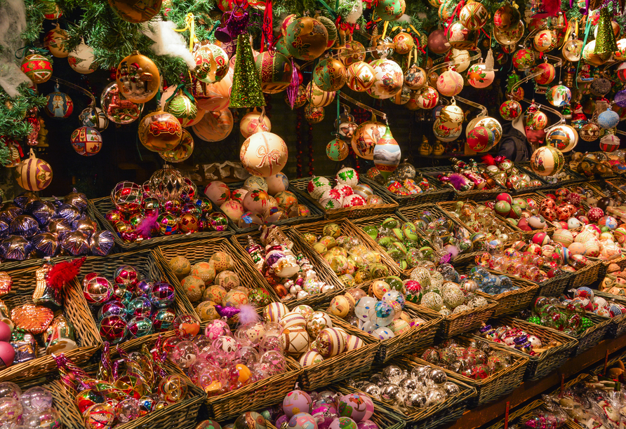 Zahlreiche Stände auf dem Weihnachtsmarkt in Wien locken mit Kunsthandwerk, weihnachtlichen Souvenirs und köstlichen Leckereien.