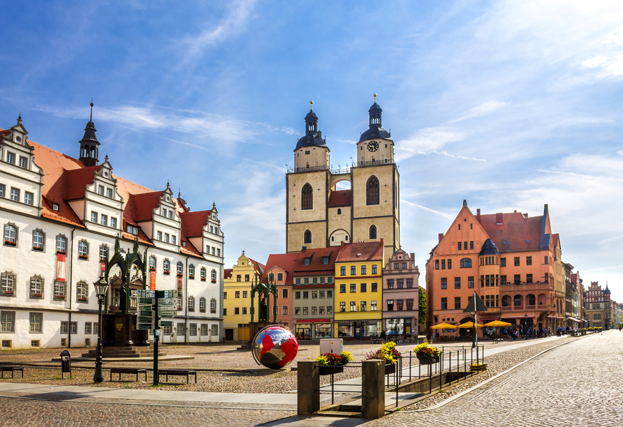 Willkommen in Wittenberg! Schlendern Sie durch die charmanten Straßen und entdecken Sie den Marktplatz mit der Kirche.