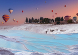 Bei Pamukkale sehen Sie die schneeweißen Kalksinterterrassen – auf Wunsch auch bei einer vor Ort buchbaren Heißluftballonfahrt.