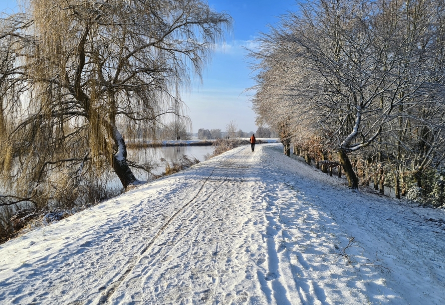 Machen Sie einen Spaziergang durch die verschneite Landschaft und erkunden Sie die Region entlang des Flusses Hunte.
